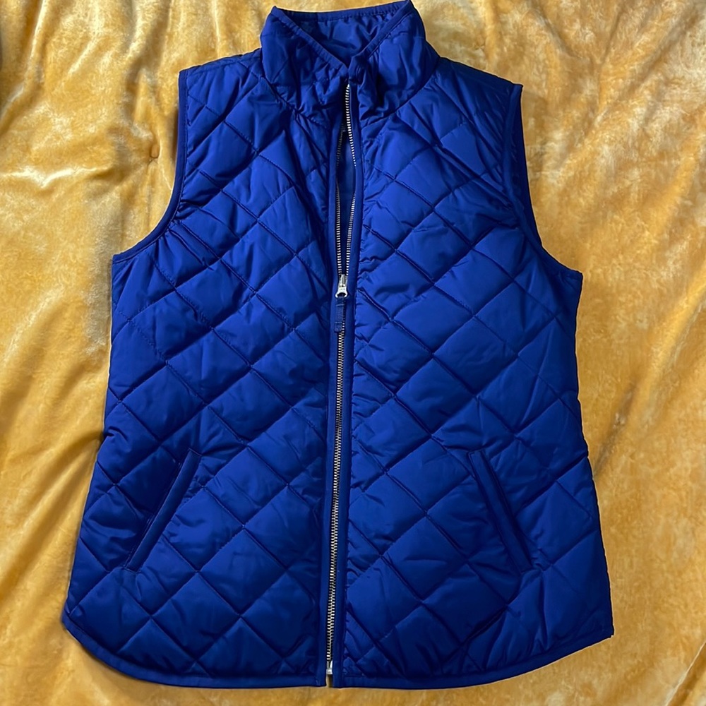 Navy blue quilted vest with gold zipper
